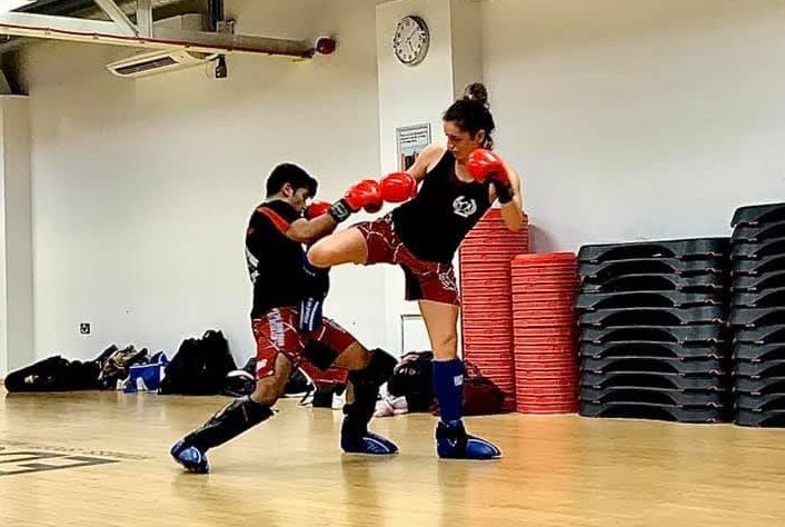 A picture of 3 pairs of people sparring in kickboxing